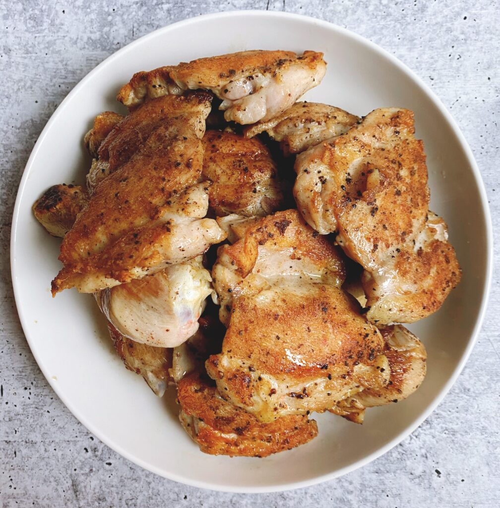 A bowl of cooked Black Garlic Chicken; breasts, thighs and legs.