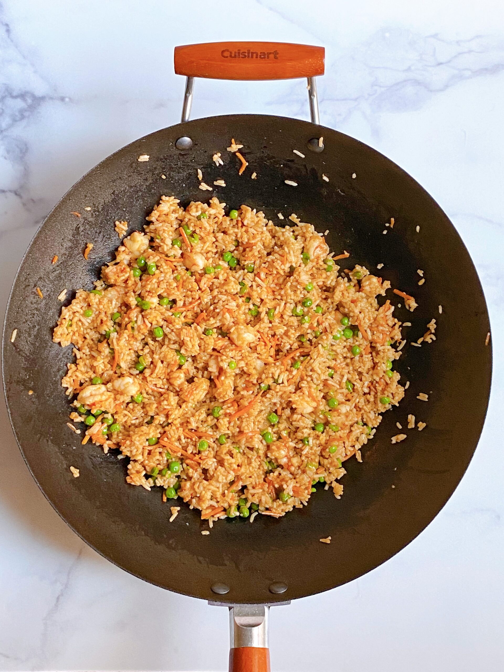 Overhead view of a wok filled with shrimp fried rice
