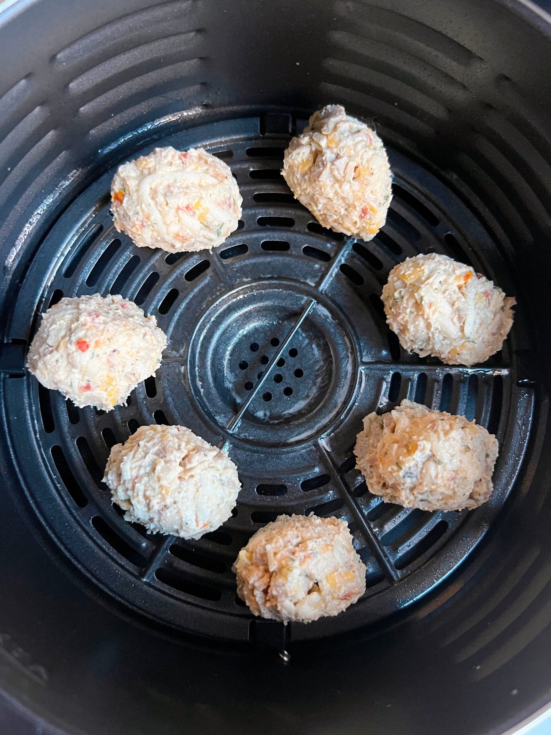 uncooked chicken sausage hash balls placed in an air fryer