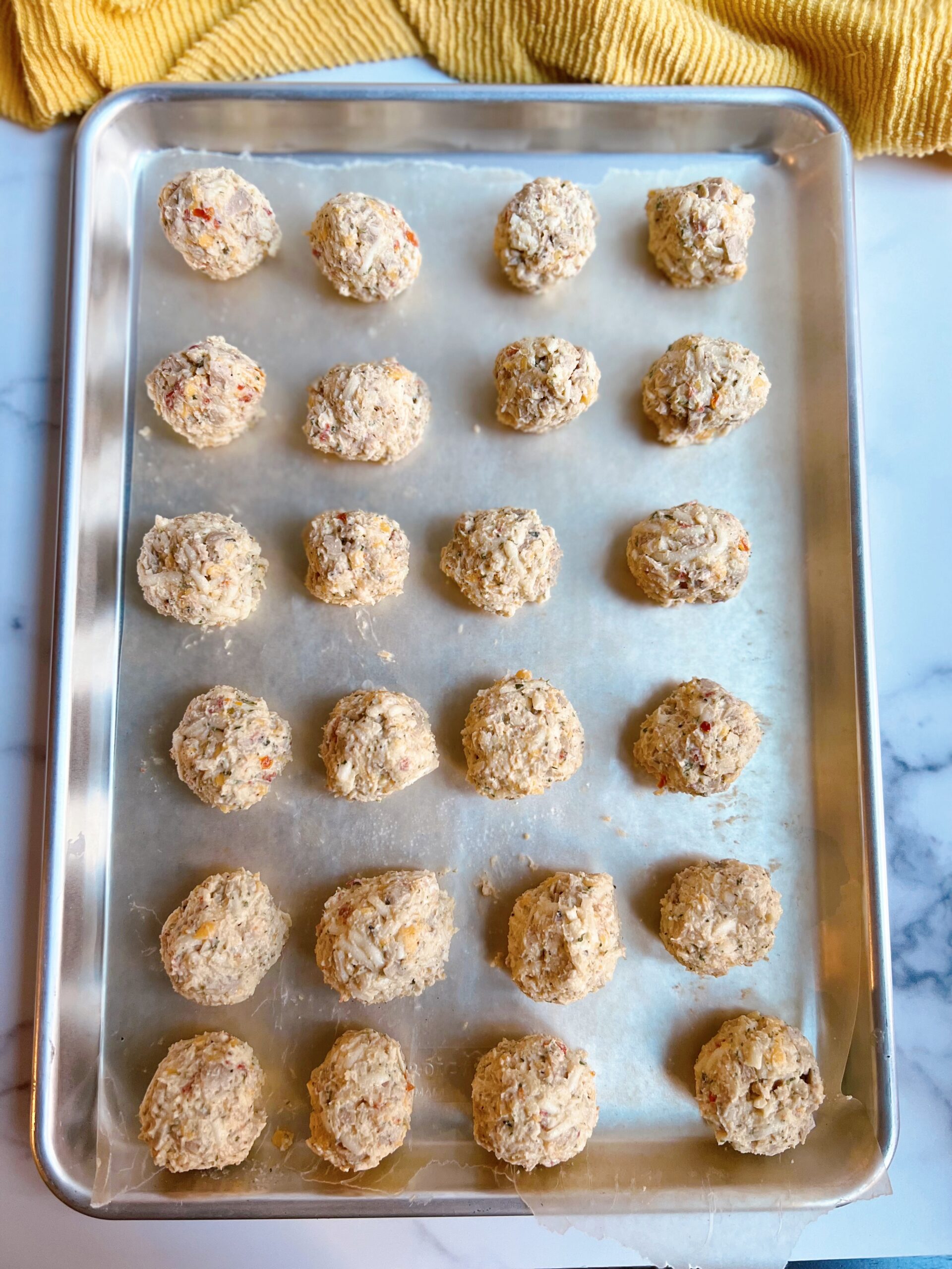 uncooked chicken sausage hash balls placed on a baking tray